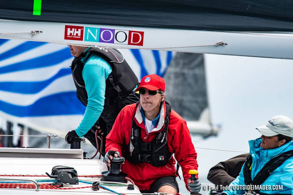 man in red jacket on sailboat