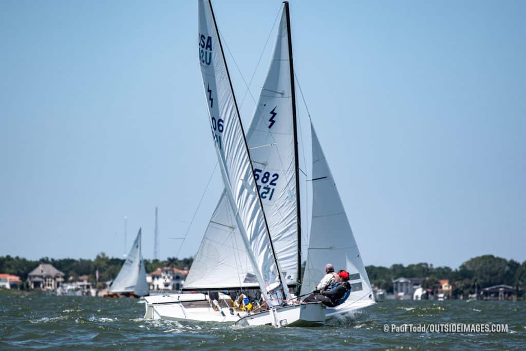 Two Lightning class sailboats crossing tacks