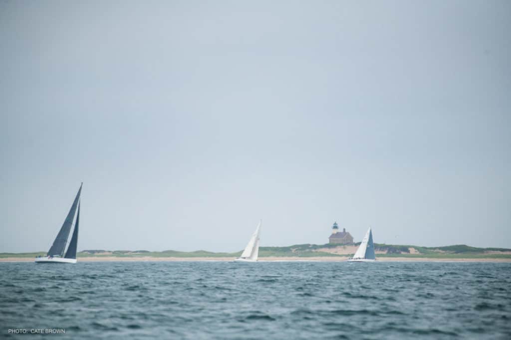 boats sailing past Block Island Lighthouse