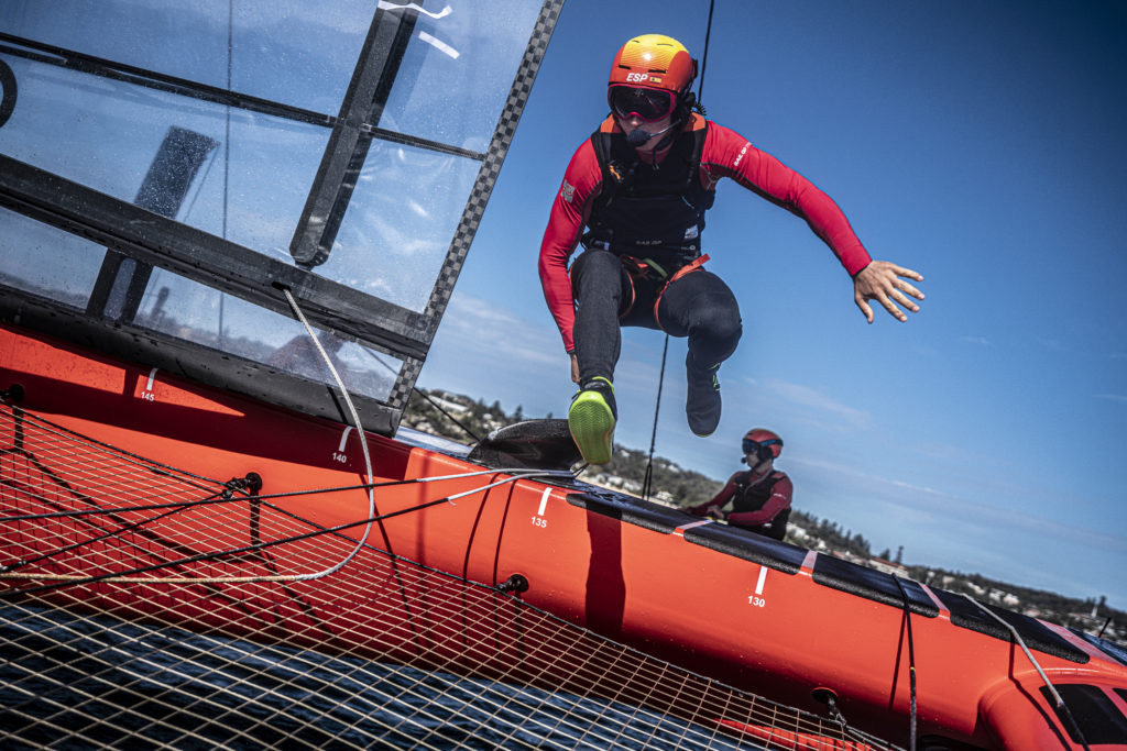 A sailor crossing the trampoline of a high-performance catamaran.