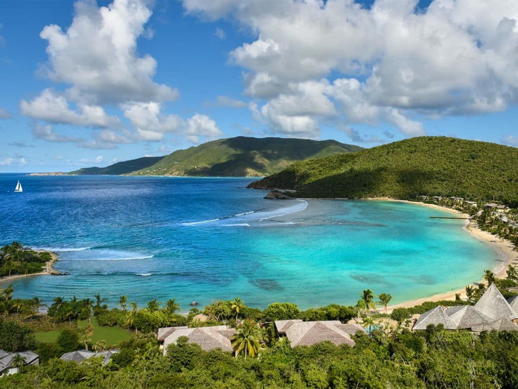 An aerial view of an island beach resort of Rosewood Little Dix Bay.