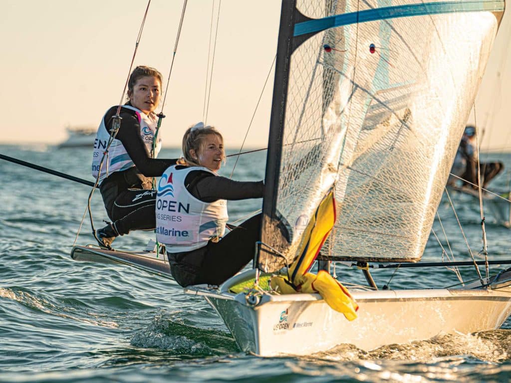 Erika Reineke and Lucy Wilmot race sailboats in the early morning hours.