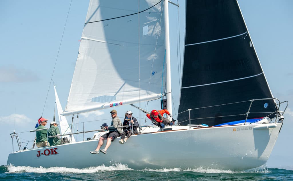 J 105 sailors racing in San Diego with crew hiking on the side of the boat