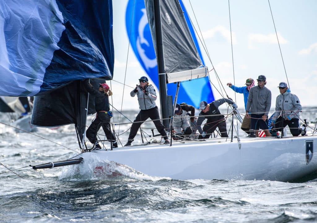 sailboat racing in Newport Rhode Island with two women on the foredeck dousing the spinnaker