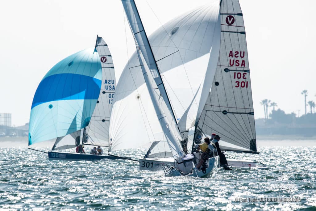 sailboats going downwind and one going upwind at a sailing regatta in California