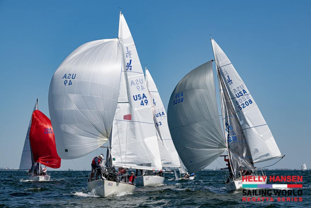 J24s approaching a race mark with spinnakers flying.