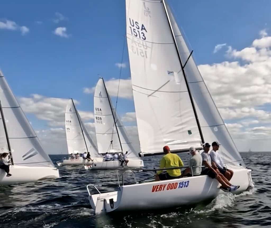 sailors on a keelboat racing in florida with sailors on the side of the boat looking out