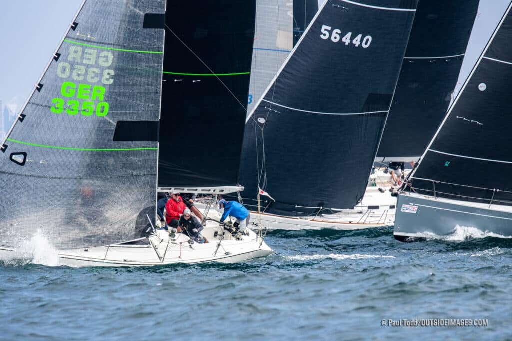 sailboats tightly packed together after a start of a race