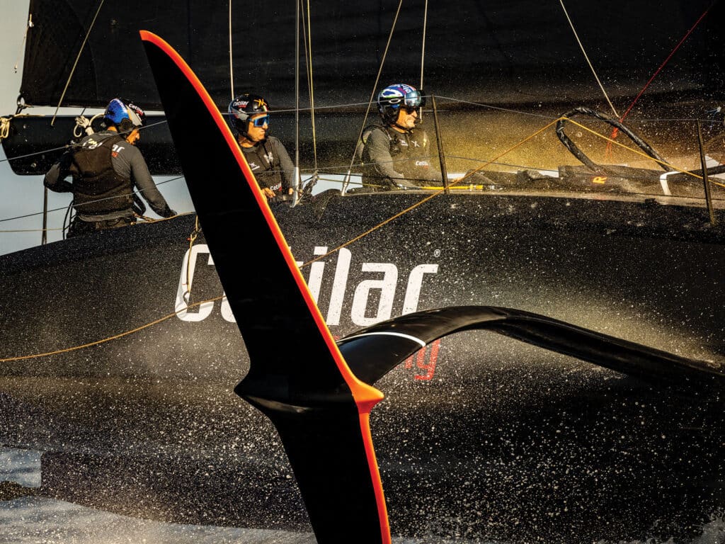 Crew in safety gear on their foiling sailboat