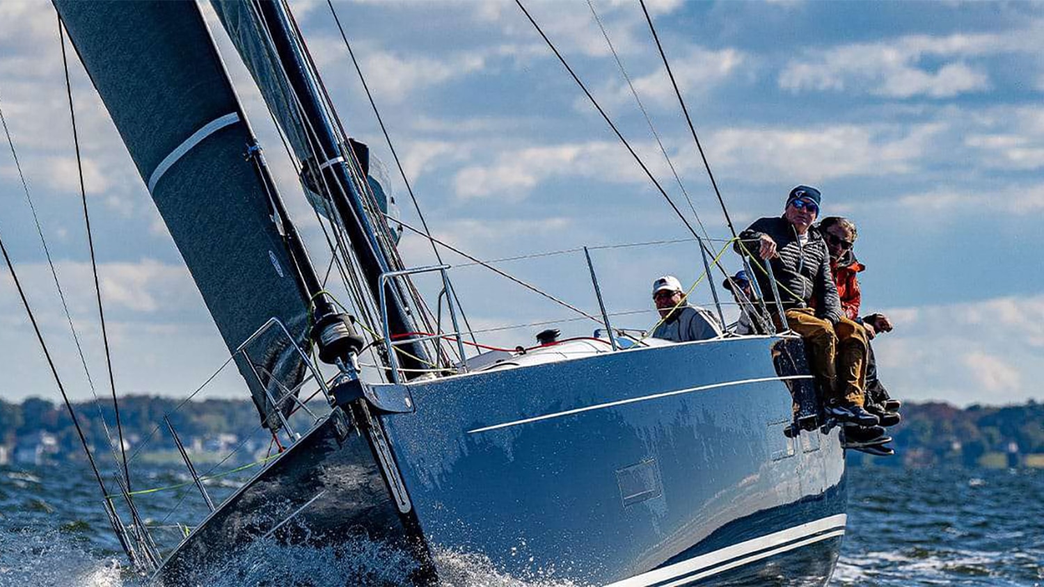 A crew sailing a boat through the bright daylight.