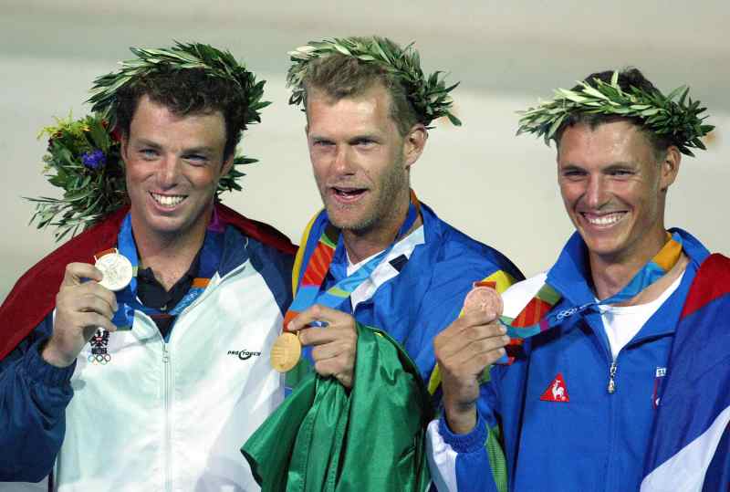 Athens, GREECE:  Brazilian gold medallist Robert Scheidt (C), Slovenia bronze medallist Vasilij Zbogar (R) and Austria silver medallist Andreas Geritzer (L) pose with their medals during the awards ceremony for the open single-handed laser class sailing event at the 2004 Olympic Games in the Agios Kosmas Olympic Center in Athens, 22 August 2004.   AFP PHOTO/MENAHEM KAHANA  (Photo credit should read MENAHEM KAHANA/AFP/Getty Images)
