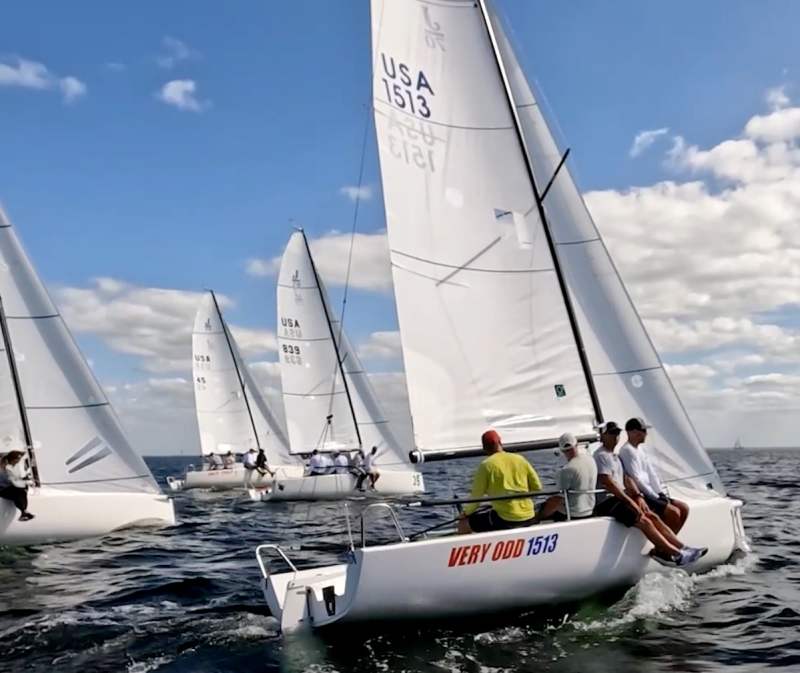 sailors on a keelboat racing in florida with sailors on the side of the boat looking out