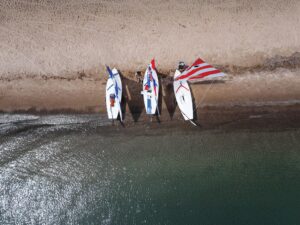 Three Sunfish sailboats onshore