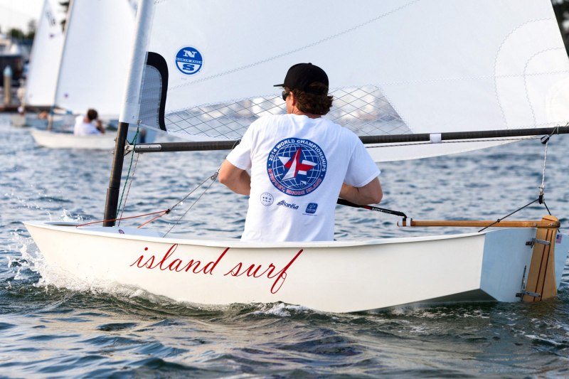 A man pilots a sailboat dinghy